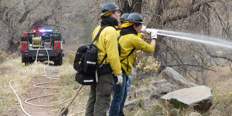 Teenagers use a fire hose